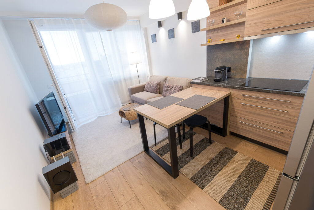 Wyjście na balkon, pokój dzienny i fragment aneksu kuchennego